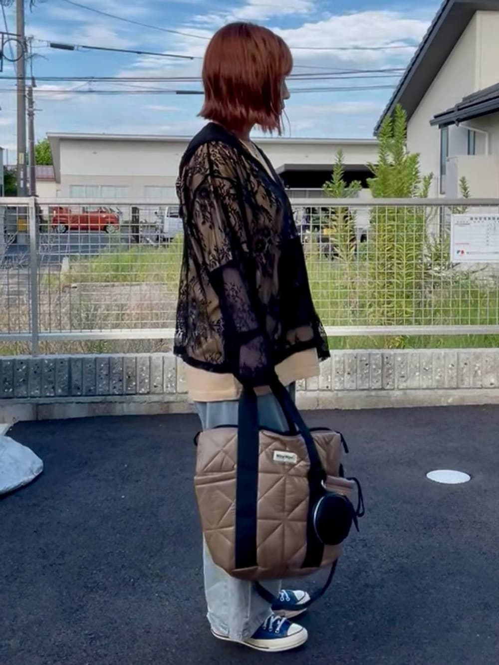 ブラック系のシャツ/ブラウス、ブルー系のスニーカー、ブルー系のデニムパンツを着用したレディースの秋コーディネートの2枚目の写真