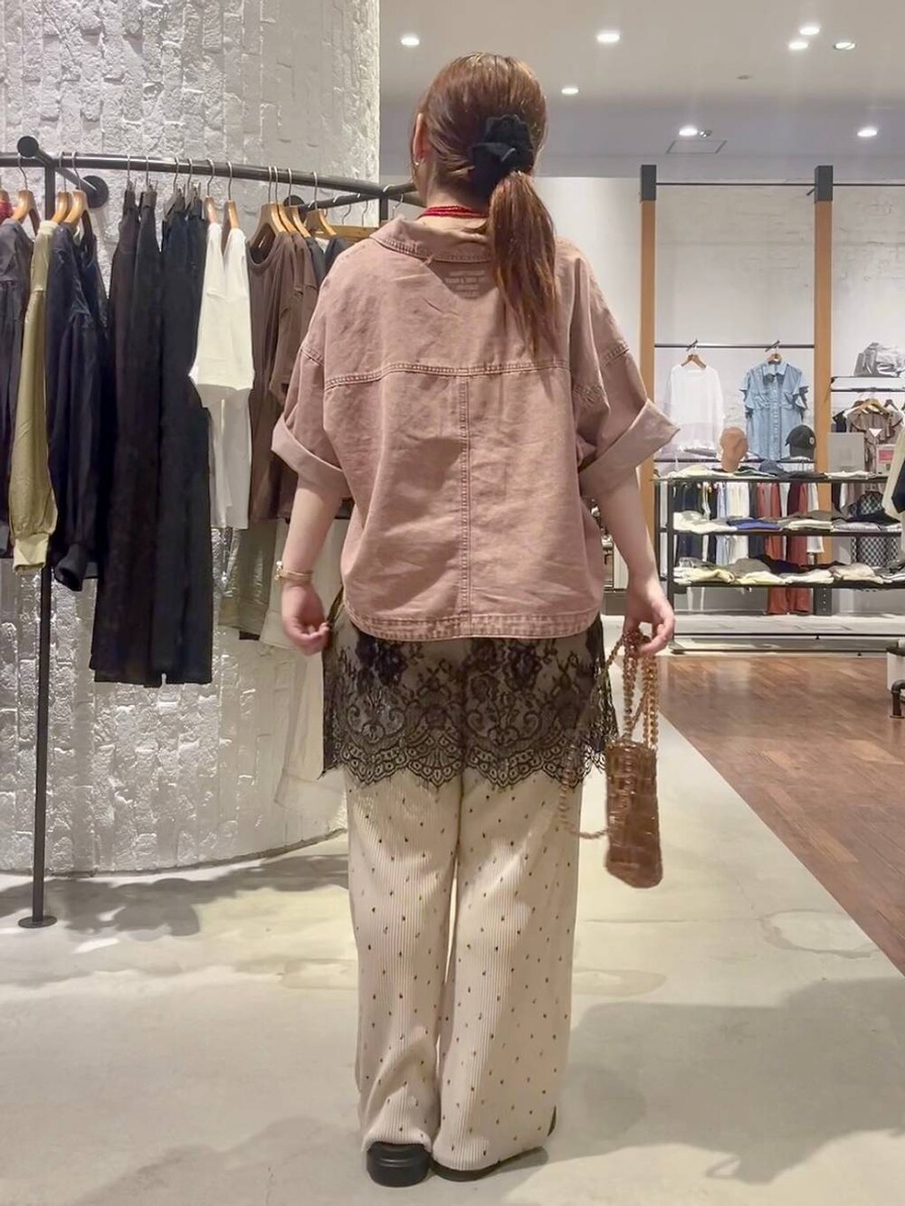 ベージュ系のその他パンツ、その他のサンダル、ブラウン系のショルダーバッグを着用したレディースの夏コーディネートの4枚目の写真