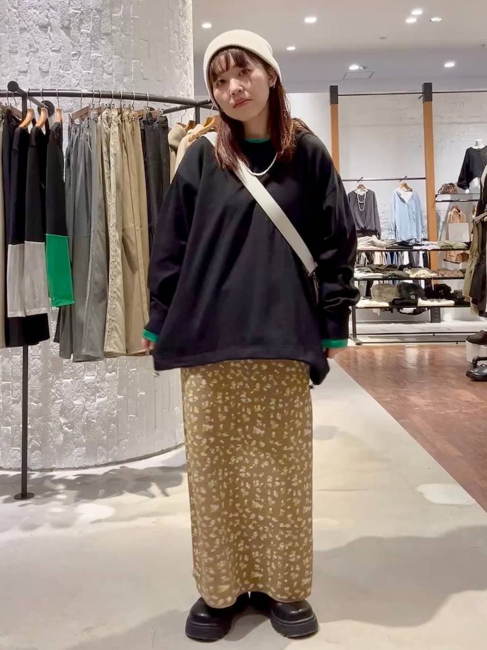 グレー系のショルダーバッグ、ブラック系のその他シューズ、ブラウン系のスカートを着用したレディースの冬コーディネートの5枚目の写真