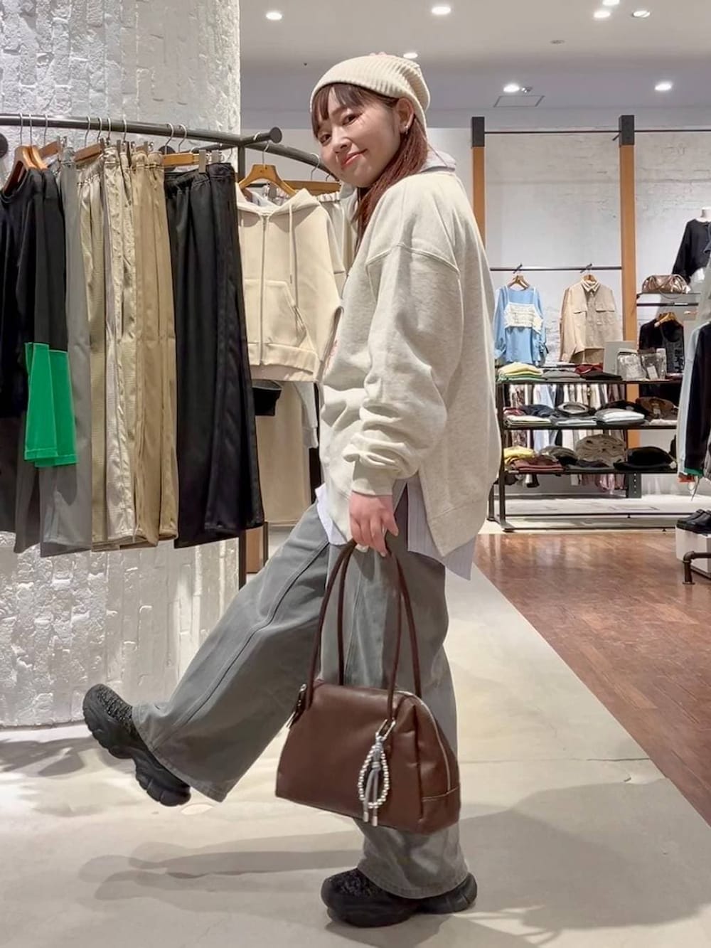 ブラック系のブーツ、グレー系のデニムパンツ、ブラウン系のボストンバッグを着用したレディースの春コーディネートの5枚目の写真