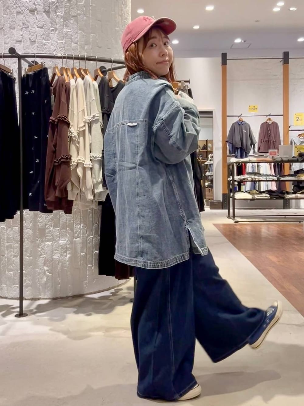 ブラック系のTシャツ/カットソー、ブルー系のスニーカー、ブルー系のデニムパンツを着用したレディースの秋コーディネートの4枚目の写真