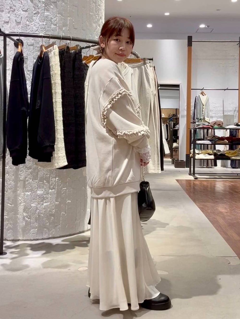 ブラック系のサンダル、ブラック系のショルダーバッグ、ホワイト系のTシャツ/カットソーを着用したレディースの冬コーディネートの3枚目の写真