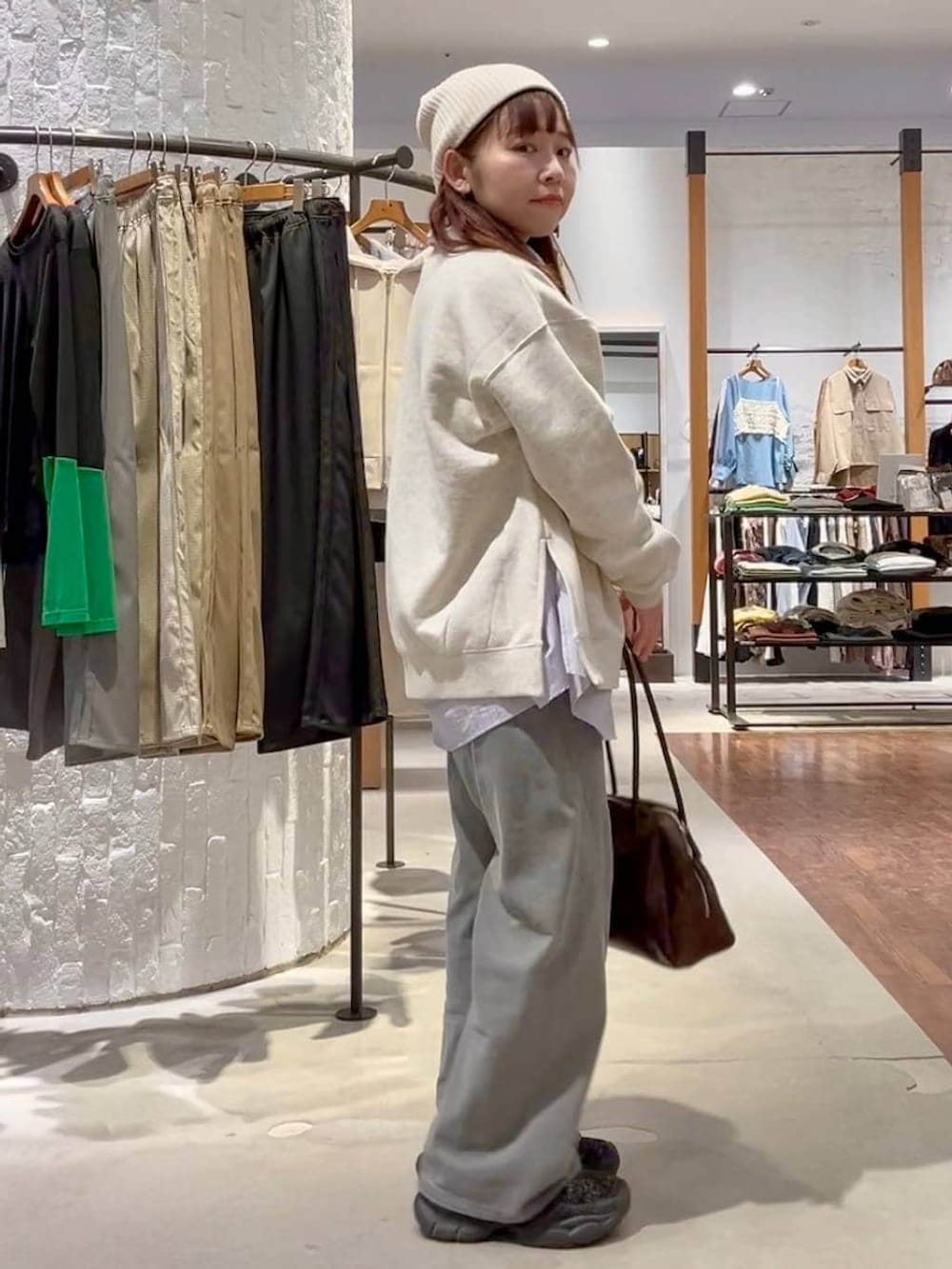 ブラック系のブーツ、グレー系のデニムパンツ、ブラウン系のボストンバッグを着用したレディースの春コーディネートの3枚目の写真