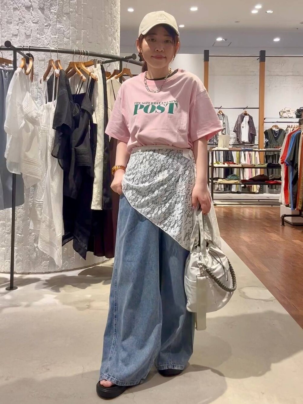 ブルー系のデニムパンツ、グレー系のショルダーバッグ、その他のサンダルを着用したレディースの夏コーディネートの2枚目の写真