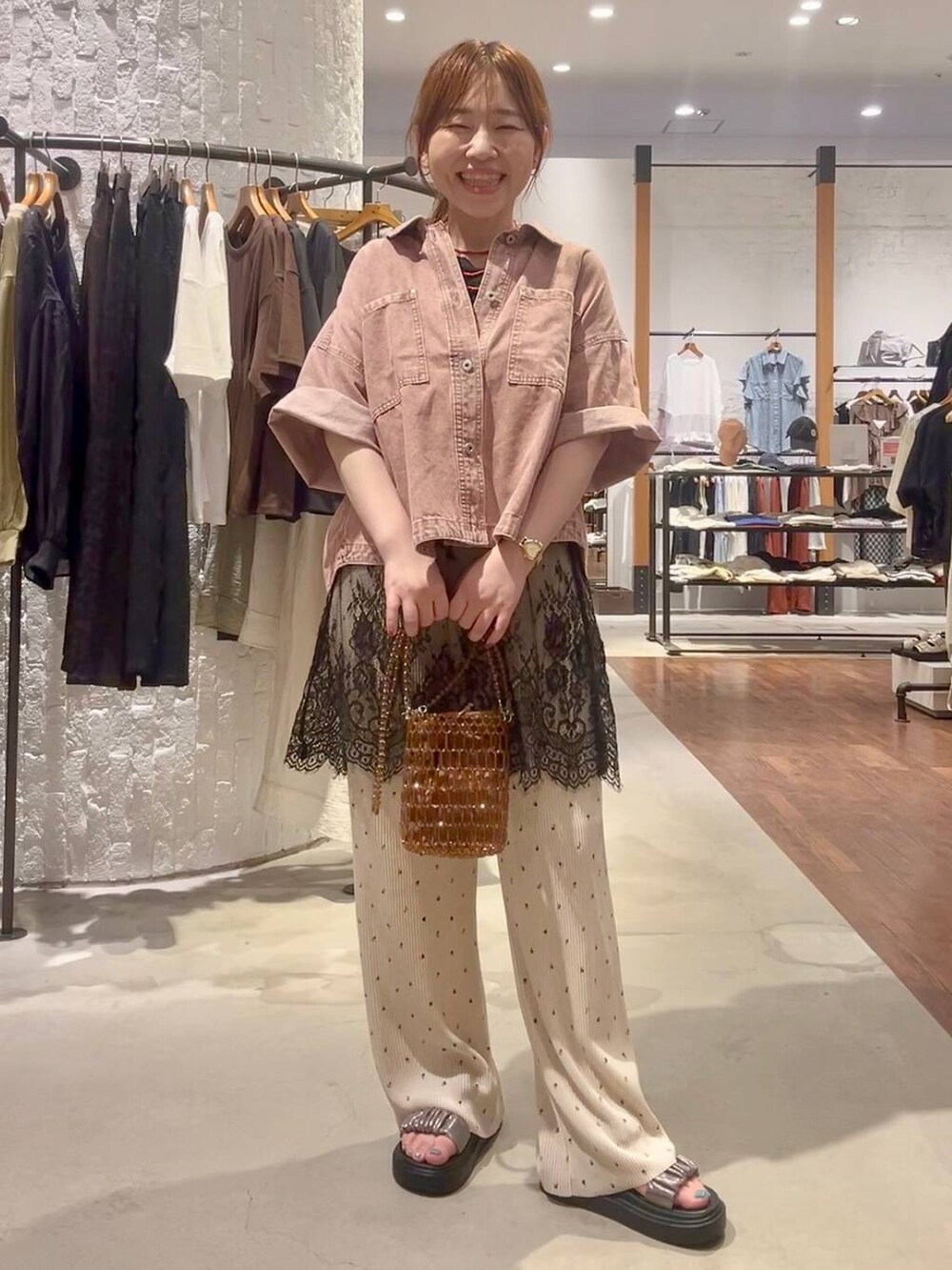 ベージュ系のその他パンツ、その他のサンダル、ブラウン系のショルダーバッグを着用したレディースの夏コーディネートの2枚目の写真