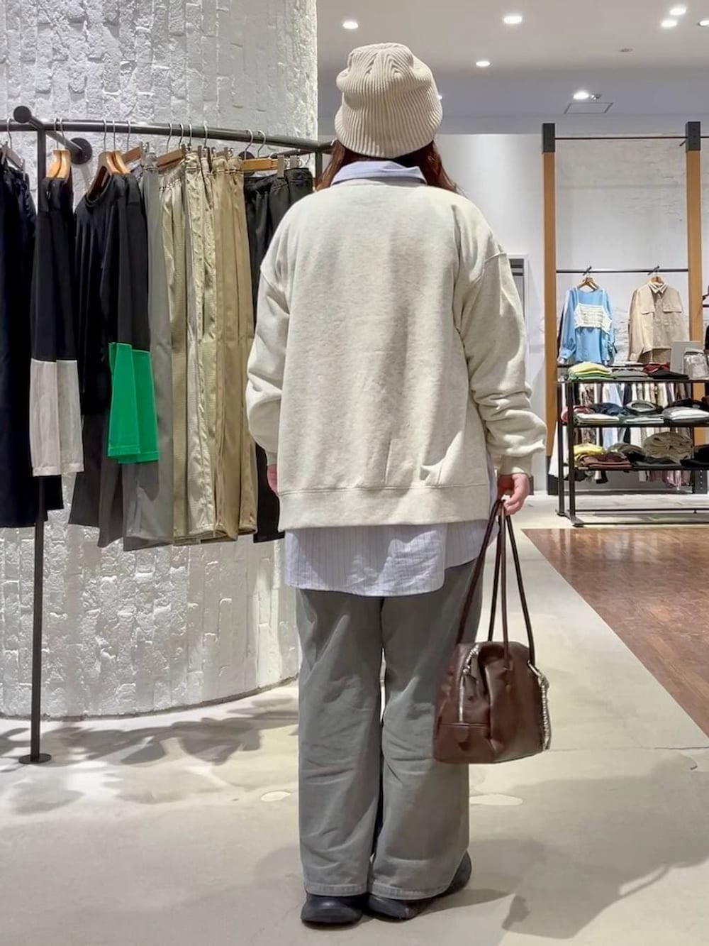 ブラック系のブーツ、グレー系のデニムパンツ、ブラウン系のボストンバッグを着用したレディースの春コーディネートの4枚目の写真