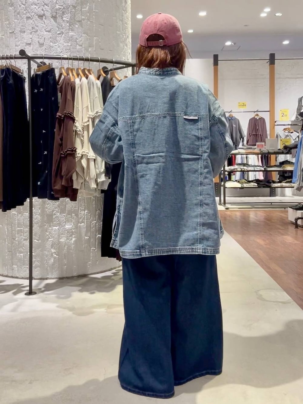 ブラック系のTシャツ/カットソー、ブルー系のスニーカー、ブルー系のデニムパンツを着用したレディースの秋コーディネートの5枚目の写真