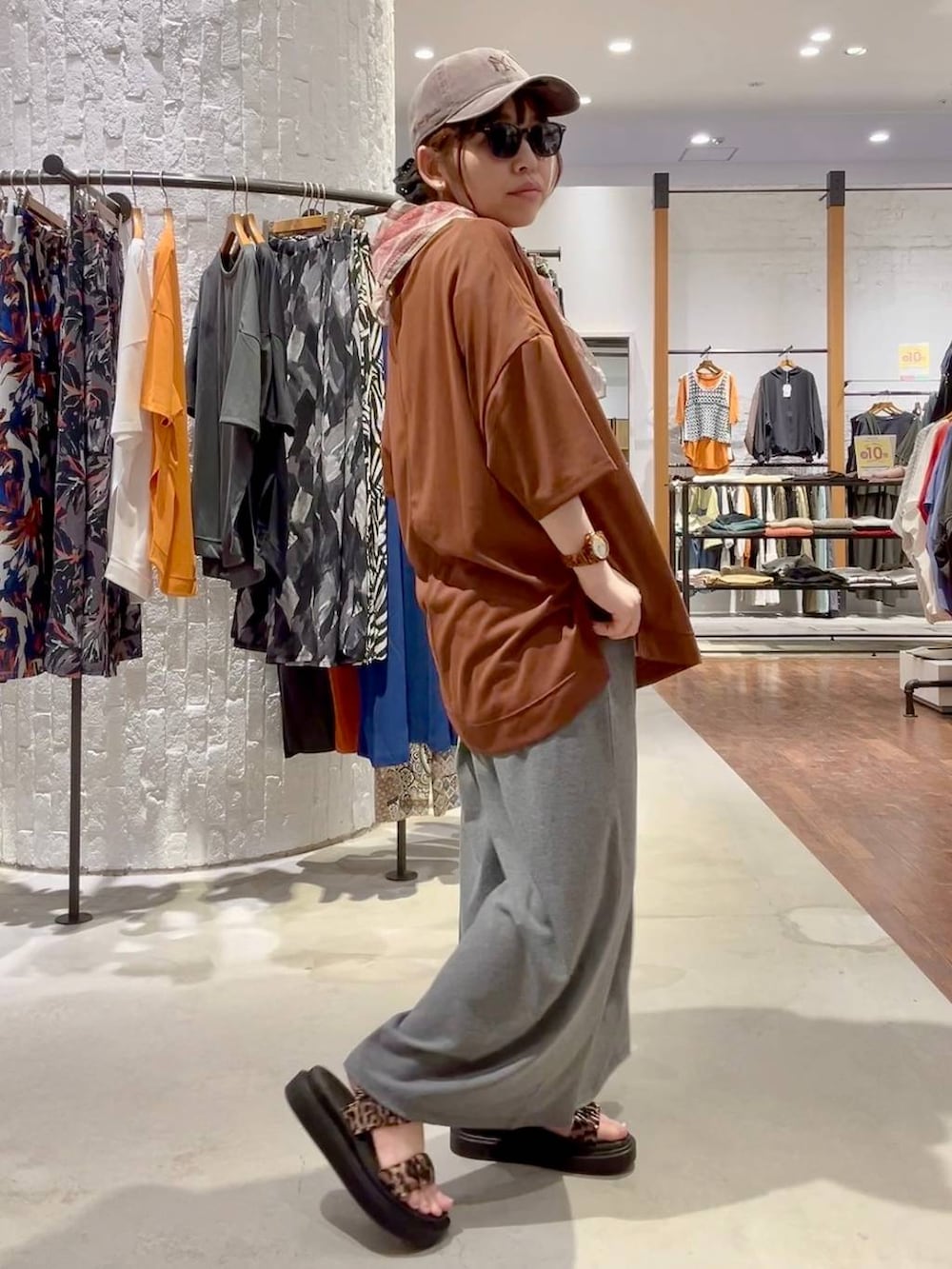 グレー系のその他パンツ、その他のサンダル、ブラウン系のTシャツ/カットソーを着用したレディースの春コーディネートの3枚目の写真