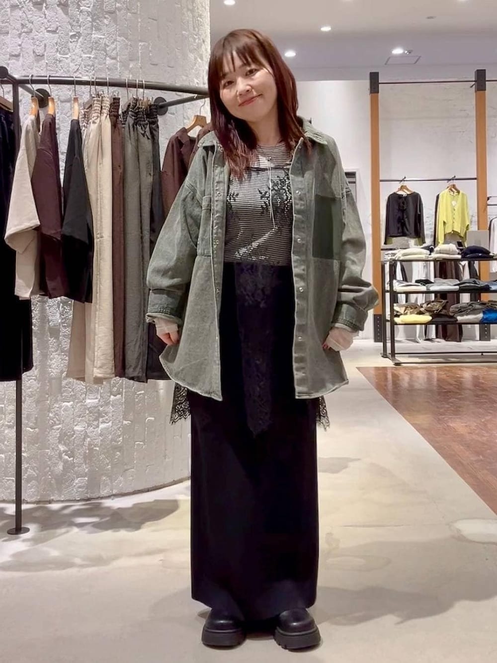 ホワイト系のTシャツ/カットソー、ブラック系のスカート、グリーン系のシャツ/ブラウスを着用したレディースの春コーディネートの2枚目の写真