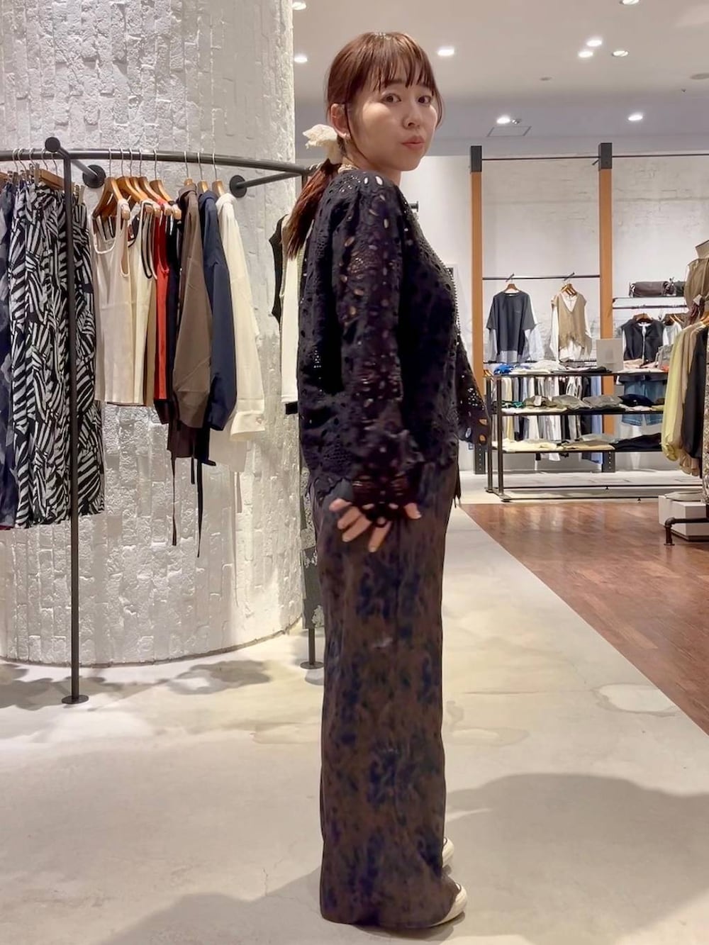 ブルー系のスニーカー、ブラウン系のその他パンツ、ブラック系のショルダーバッグを着用したレディースの春コーディネートの3枚目の写真