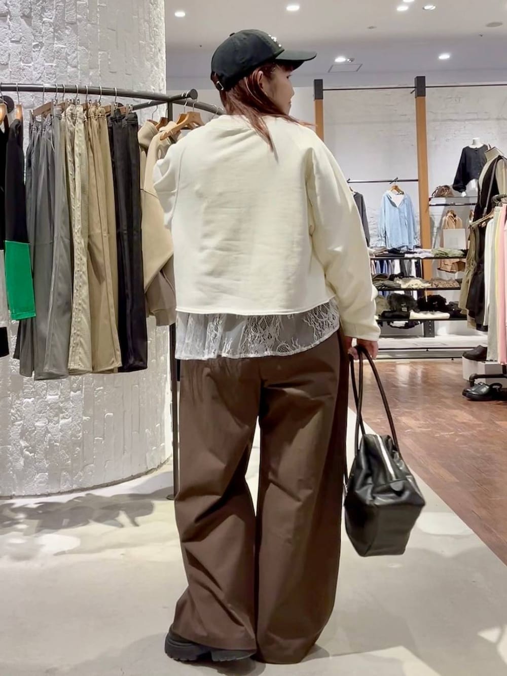 ホワイト系のTシャツ/カットソー、グリーン系のその他パンツ、ブラック系のボストンバッグを着用したレディースの冬コーディネートの5枚目の写真