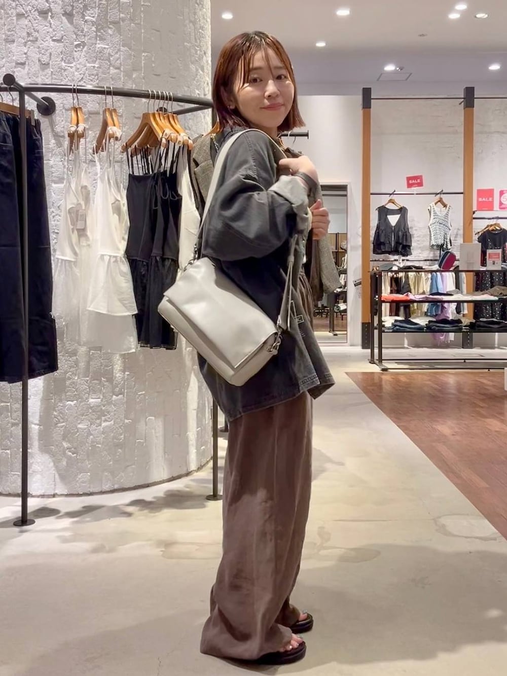 ブラック系のシャツ/ブラウス、ブラウン系のその他パンツ、グレー系のショルダーバッグを着用したレディースの夏コーディネートの3枚目の写真
