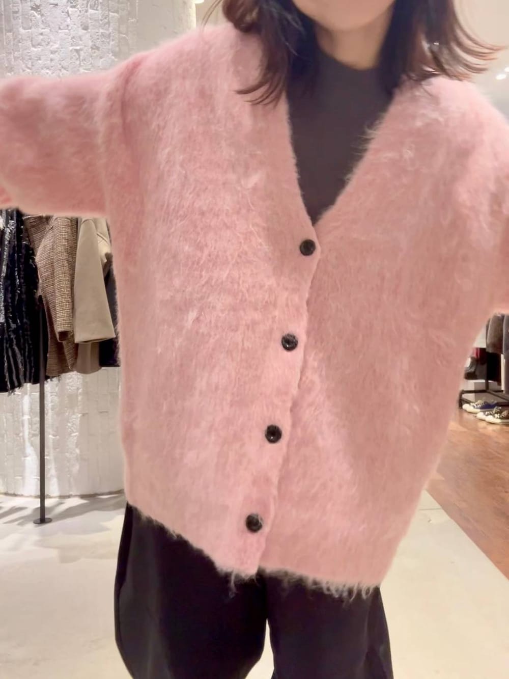 グレー系のニット/セーター、ブラック系のその他パンツ、ピンク系のカーディガン/ボレロを着用したレディースの秋コーディネートの6枚目の写真