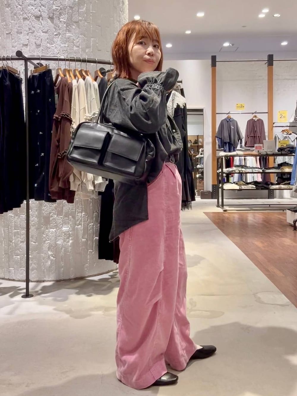 ピンク系のその他パンツ、ブラック系のボストンバッグ、ブラック系のTシャツ/カットソーを着用したレディースの秋コーディネートの3枚目の写真