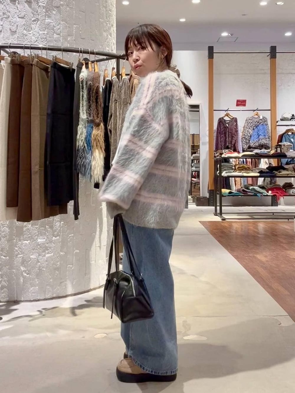 ブラック系のボストンバッグ、ホワイト系のシャツ/ブラウス、ベージュ系のその他シューズを着用したレディースの冬コーディネートの3枚目の写真