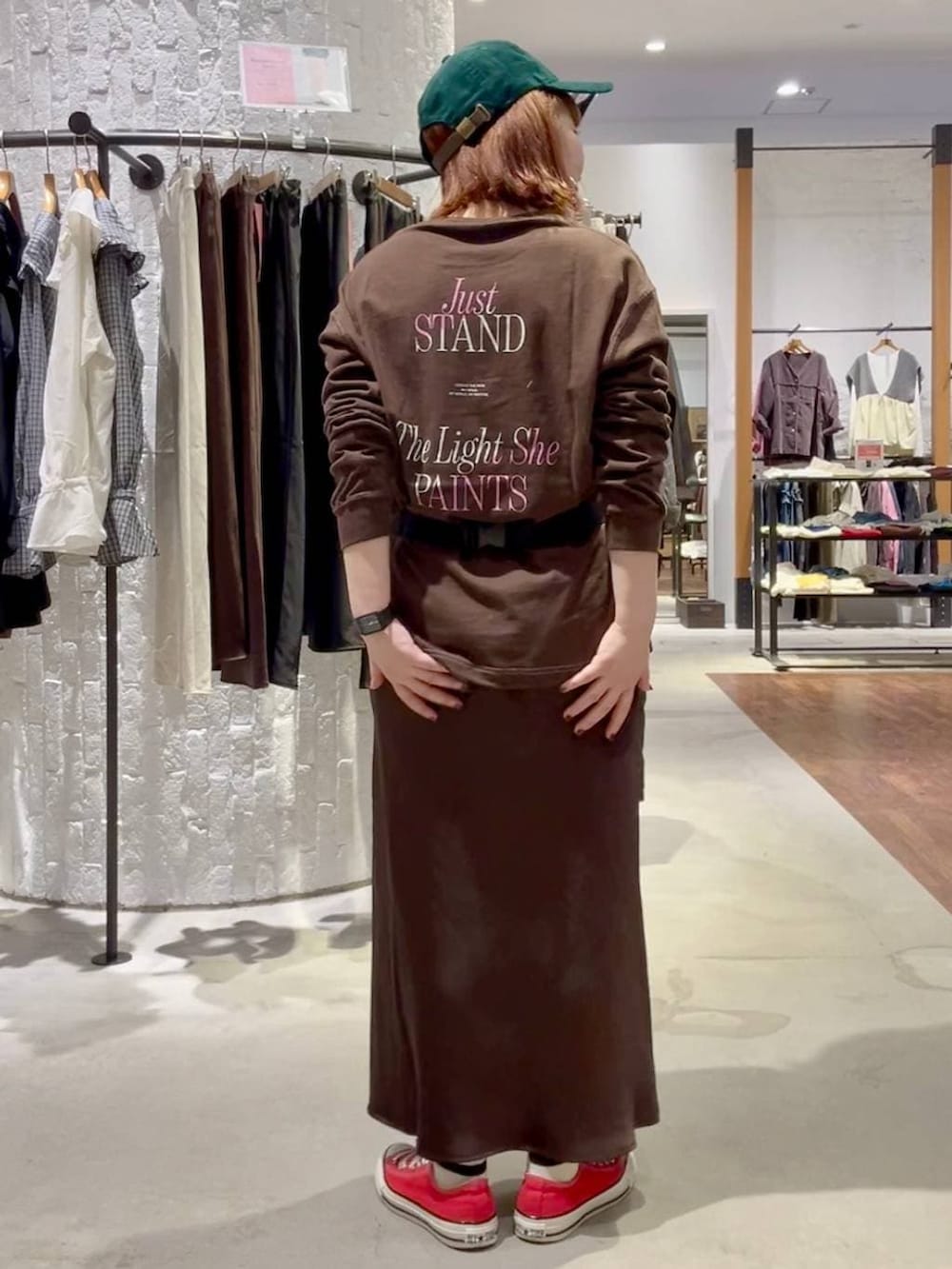 ブラウン系のスカート、ブラウン系のTシャツ/カットソー、レッド系のスニーカーを着用したレディースの秋コーディネートの5枚目の写真