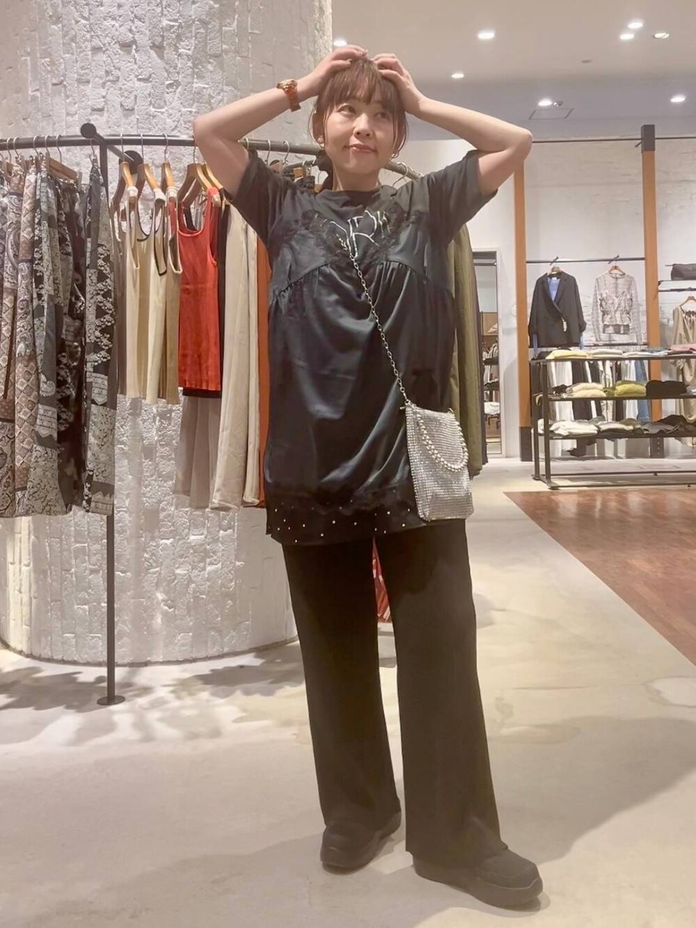 ブラック系のその他パンツ、ブラック系のその他シューズ、シルバー系のショルダーバッグを着用したレディースの春コーディネートの2枚目の写真