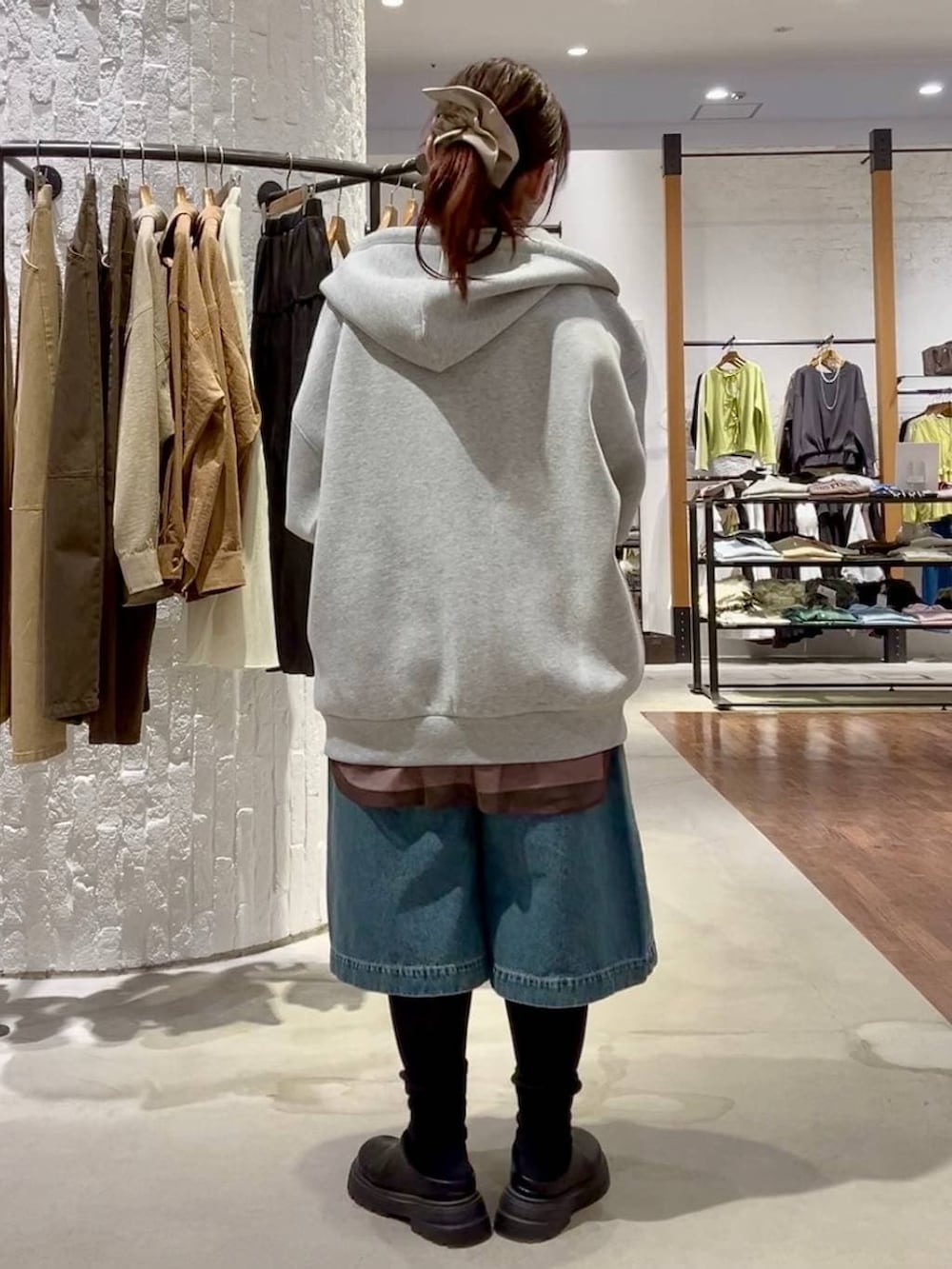 グレー系のパーカー、ブラック系のショルダーバッグ、ブラック系のその他シューズを着用したレディースの冬コーディネートの4枚目の写真