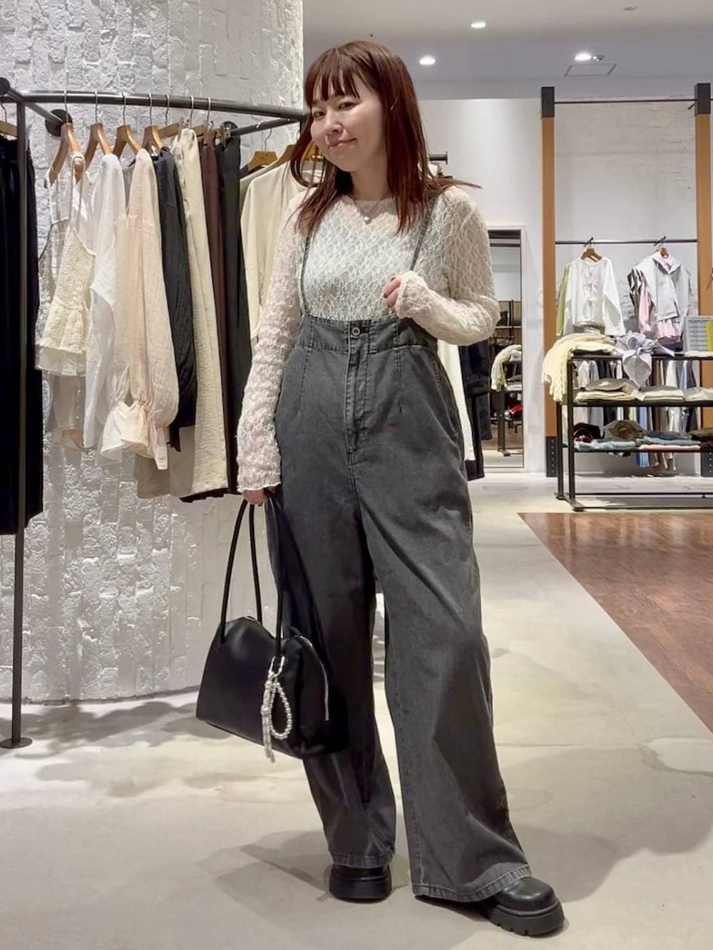 ブラック系のボストンバッグ、ブラック系のその他シューズ、グレー系のサロペット/オーバーオールを着用したレディースの春コーディネートの2枚目の写真