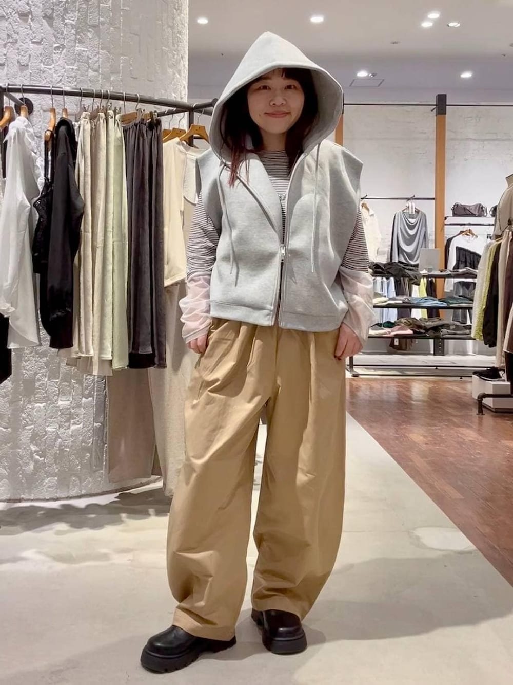 ホワイト系のTシャツ/カットソー、グレー系のベスト、ブラック系のその他シューズを着用したレディースの春コーディネートの5枚目の写真