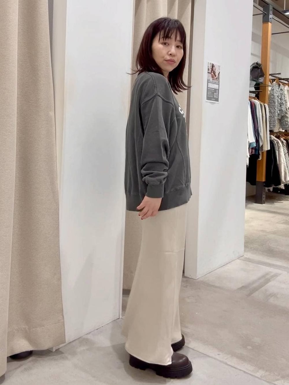 ホワイト系のスカート、ホワイト系のその他アウター、ブラウン系のブーツを着用したレディースの秋コーディネートの7枚目の写真