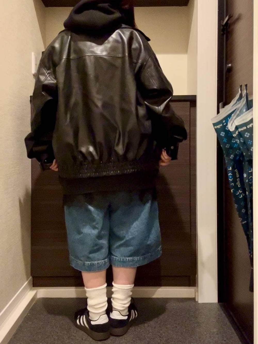 ブラック系のブルゾン、ホワイト系のTシャツ/カットソー、ブラック系のスニーカーを着用したレディースの春コーディネートの4枚目の写真