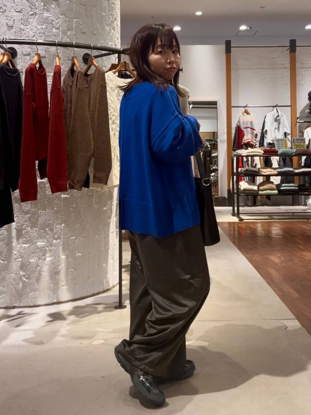 ブルー系のニット/セーター、その他のTシャツ/カットソー、ブラック系のショルダーバッグを着用したレディースの秋コーディネートの4枚目の写真