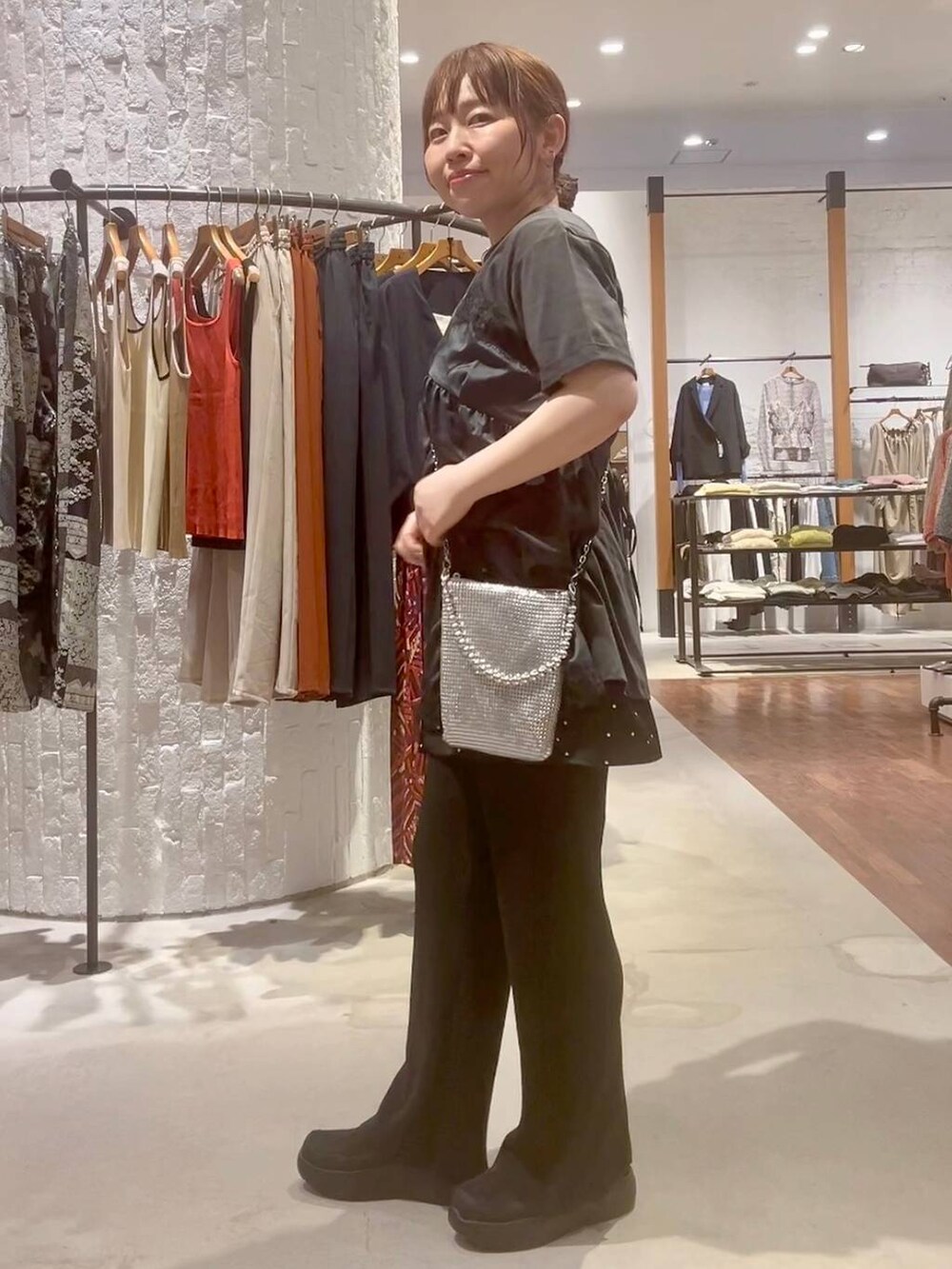 ブラック系のその他パンツ、ブラック系のその他シューズ、シルバー系のショルダーバッグを着用したレディースの春コーディネートの4枚目の写真
