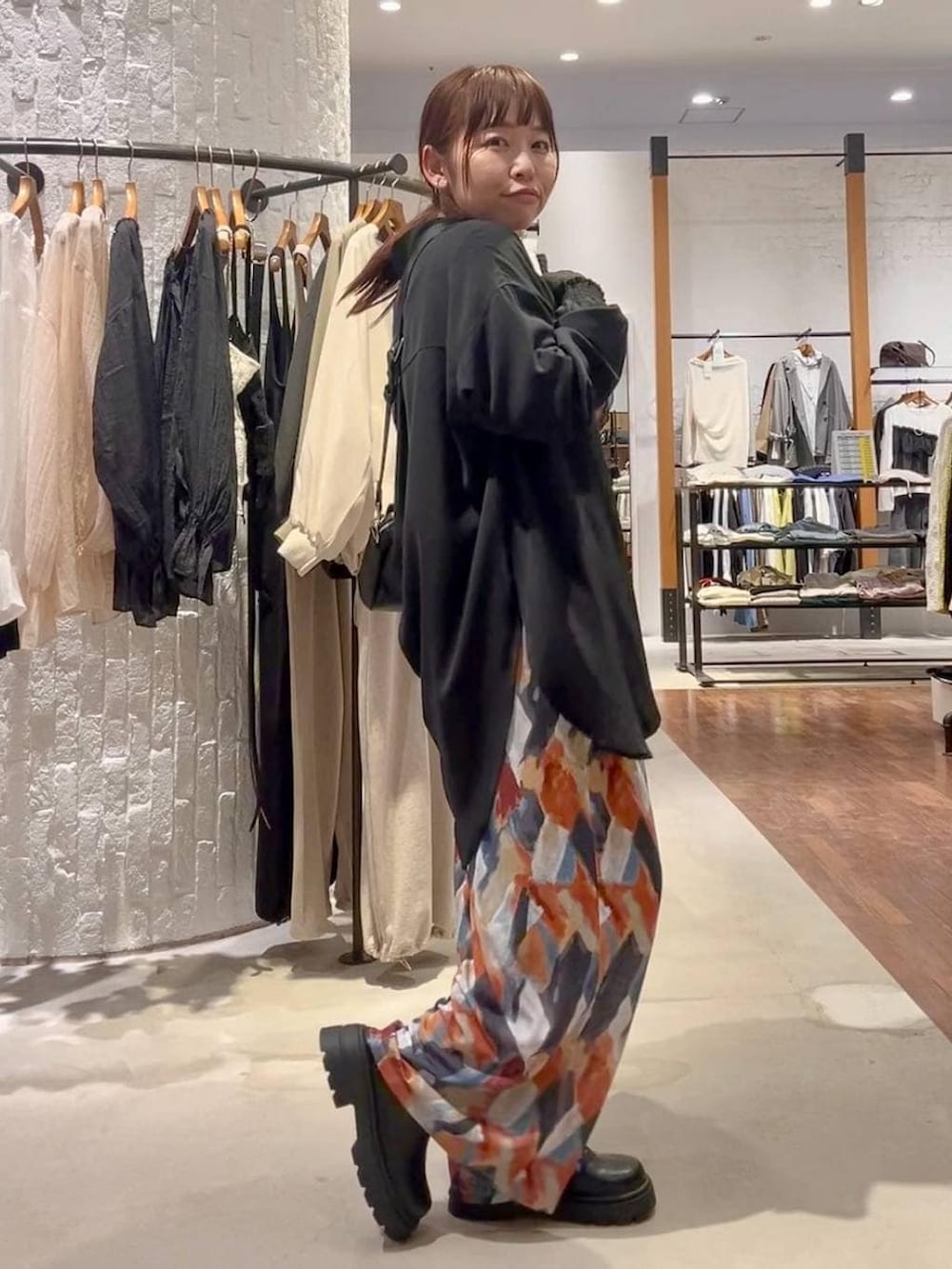 ブルー系のその他パンツ、ブラック系のショルダーバッグ、ブラック系のシャツ/ブラウスを着用したレディースの春コーディネートの3枚目の写真