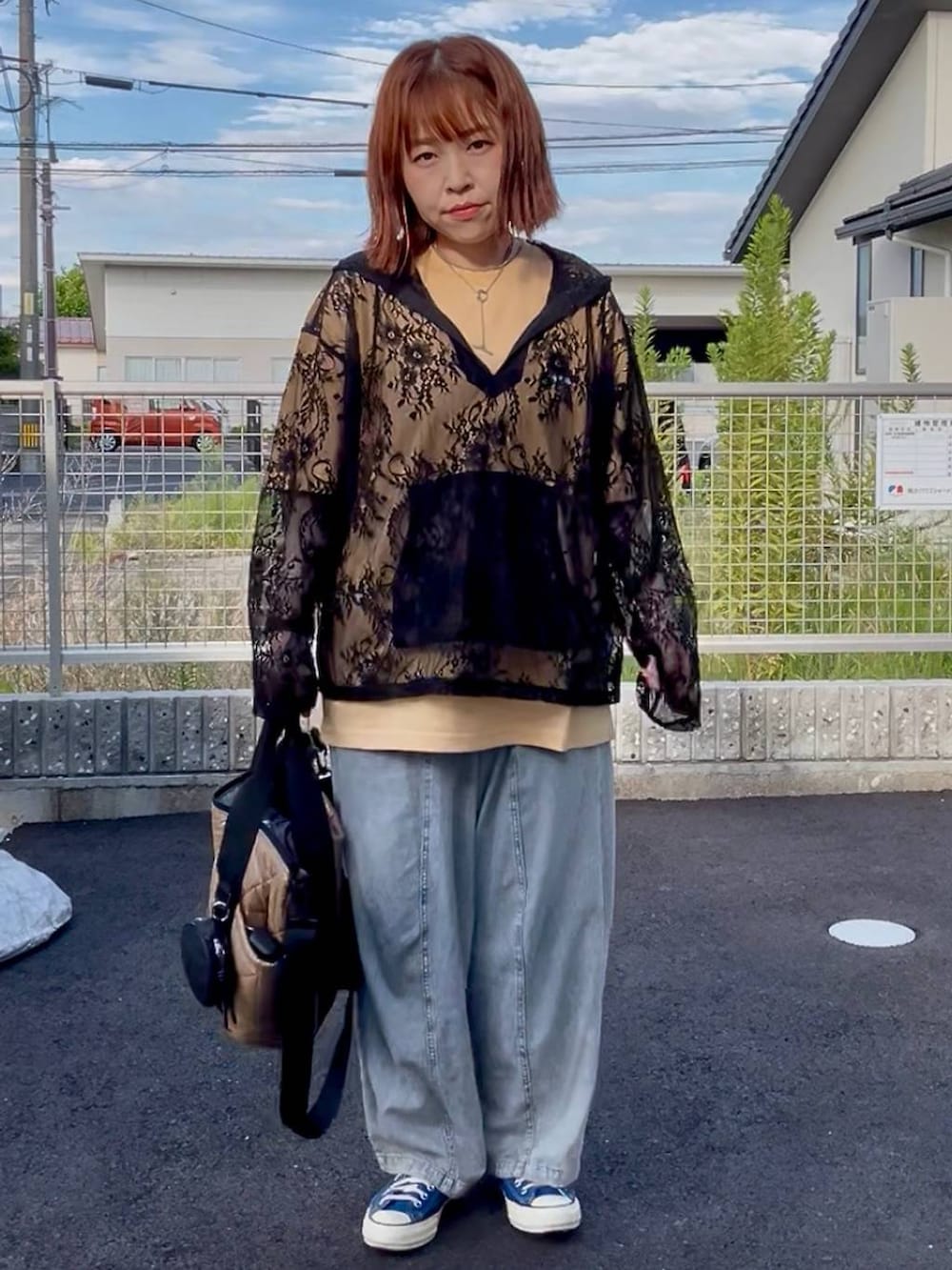 ブラック系のシャツ/ブラウス、ブルー系のスニーカー、ブルー系のデニムパンツを着用したレディースの秋コーディネートの3枚目の写真