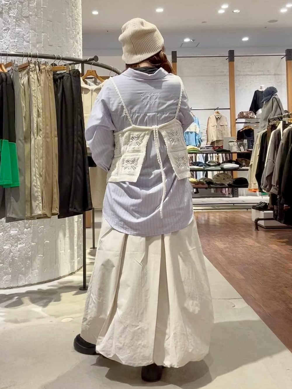 ブラック系のサンダル、ベージュ系のスカート、グレー系のショルダーバッグを着用したレディースの冬コーディネートの4枚目の写真