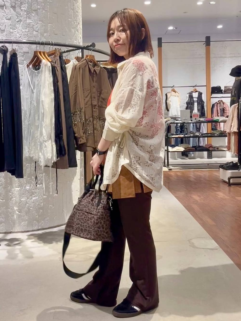 ホワイト系のシャツ/ブラウス、レッド系のTシャツ/カットソー、ブラック系のスニーカーを着用したレディースの夏コーディネートの3枚目の写真