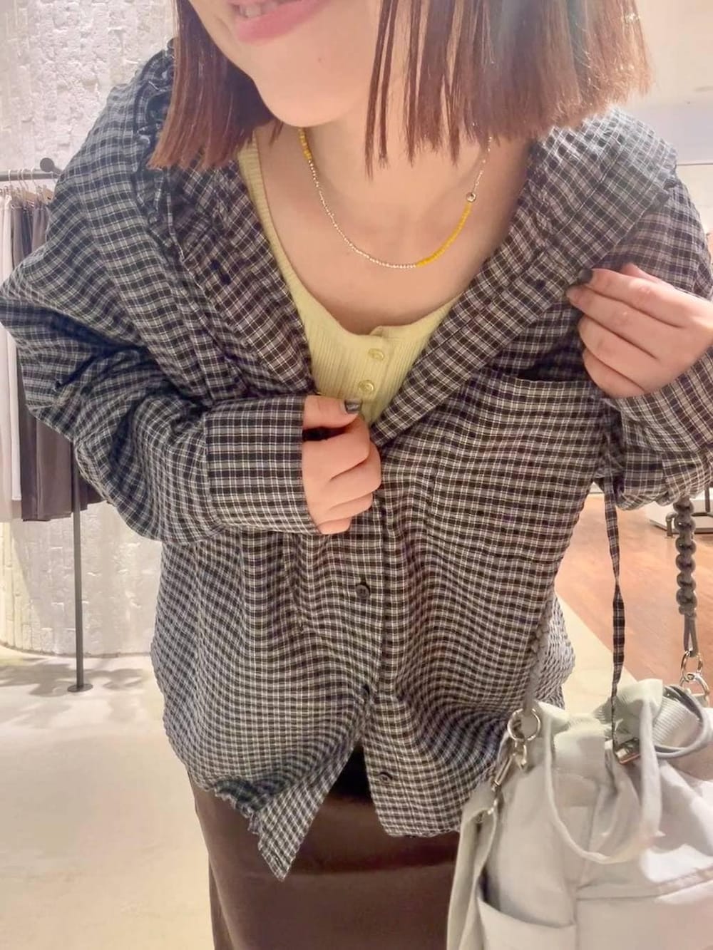 グレー系のサンダル、ブラウン系のスカート、ブラック系のシャツ/ブラウスを着用したレディースの夏コーディネートの6枚目の写真
