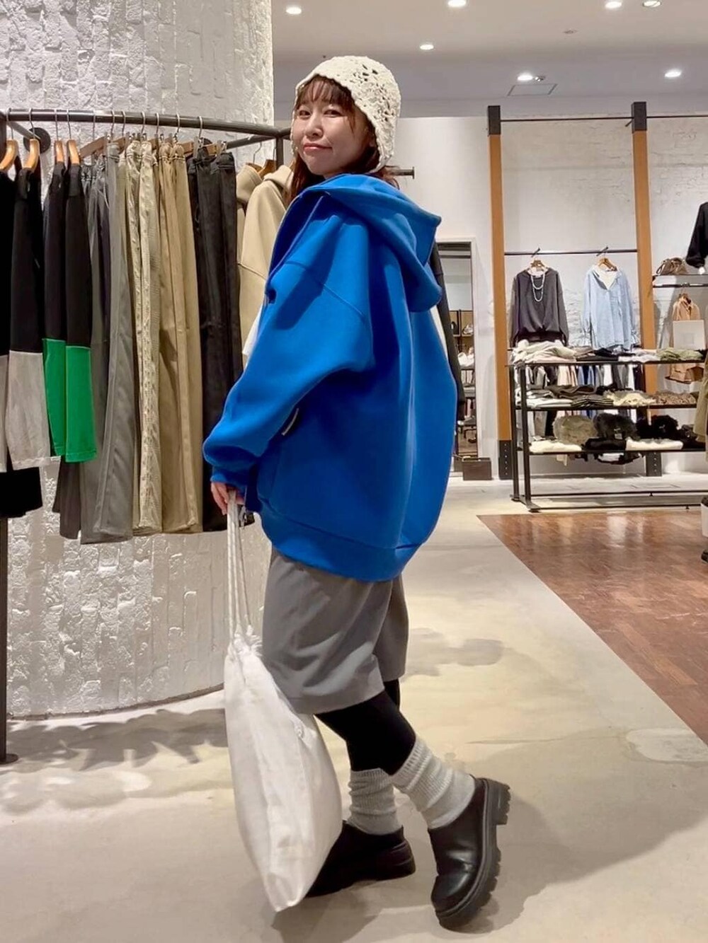 ブルー系のパーカー、グレー系のその他パンツ、ブラック系のその他シューズを着用したレディースの冬コーディネートの9枚目の写真