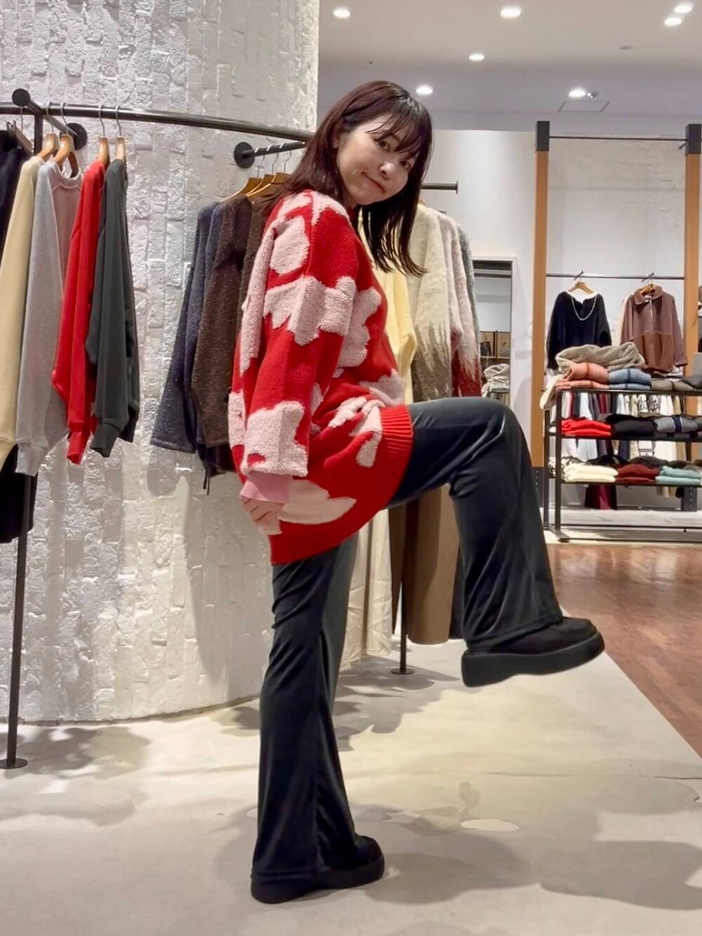 グレー系のニット/セーター、ブルー系のその他パンツ、ブラック系のショルダーバッグを着用したレディースの秋コーディネートの4枚目の写真