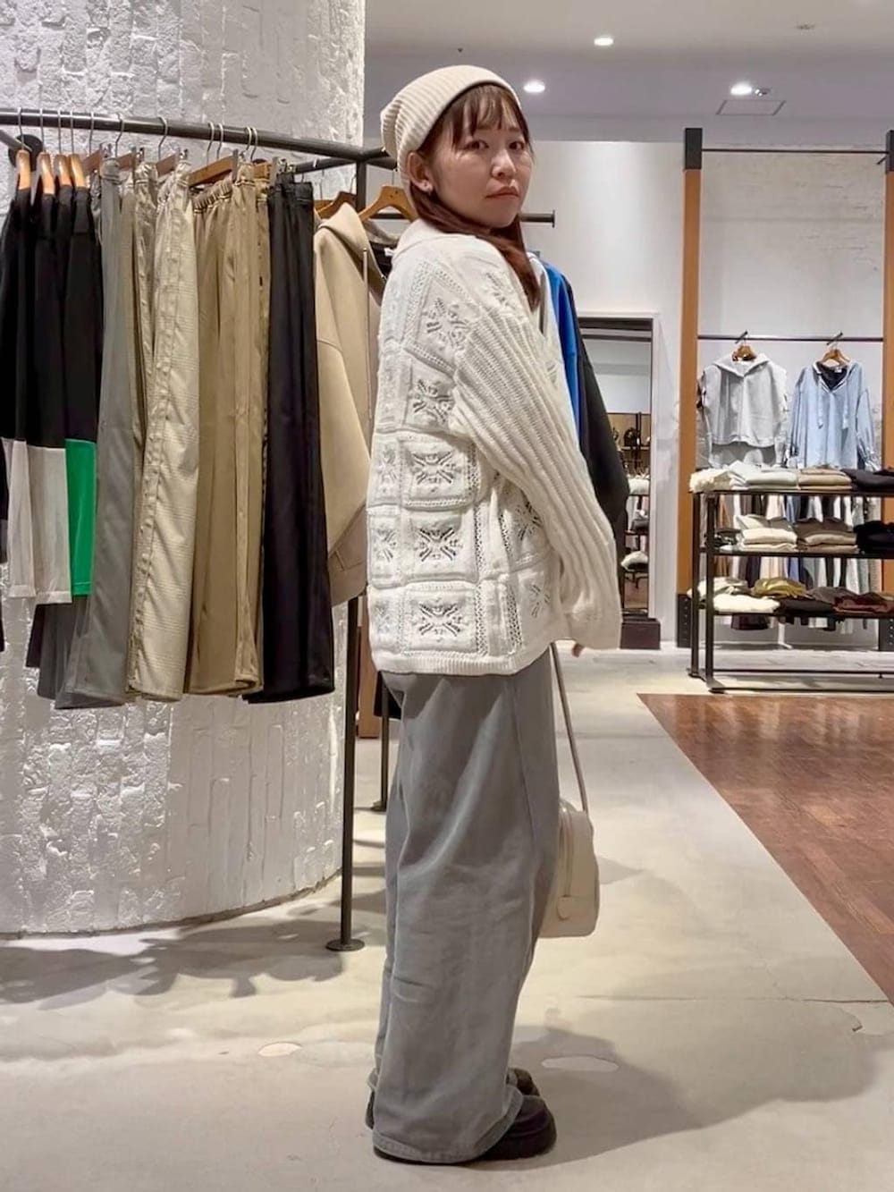 パープル系のTシャツ/カットソー、グレー系のデニムパンツ、ホワイト系のボストンバッグを着用したレディースの冬コーディネートの3枚目の写真