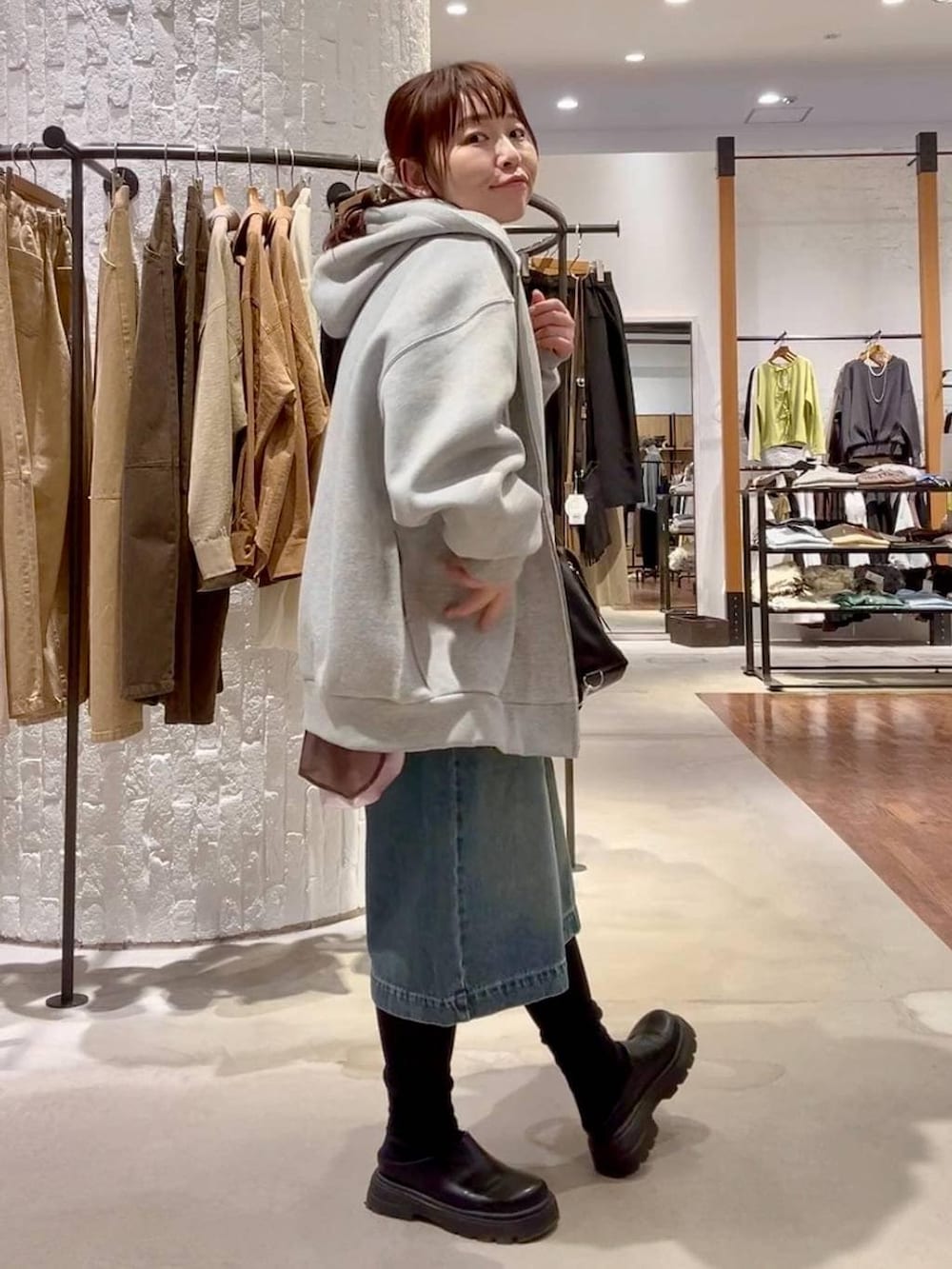 グレー系のパーカー、ブラック系のショルダーバッグ、ブラック系のその他シューズを着用したレディースの冬コーディネートの7枚目の写真