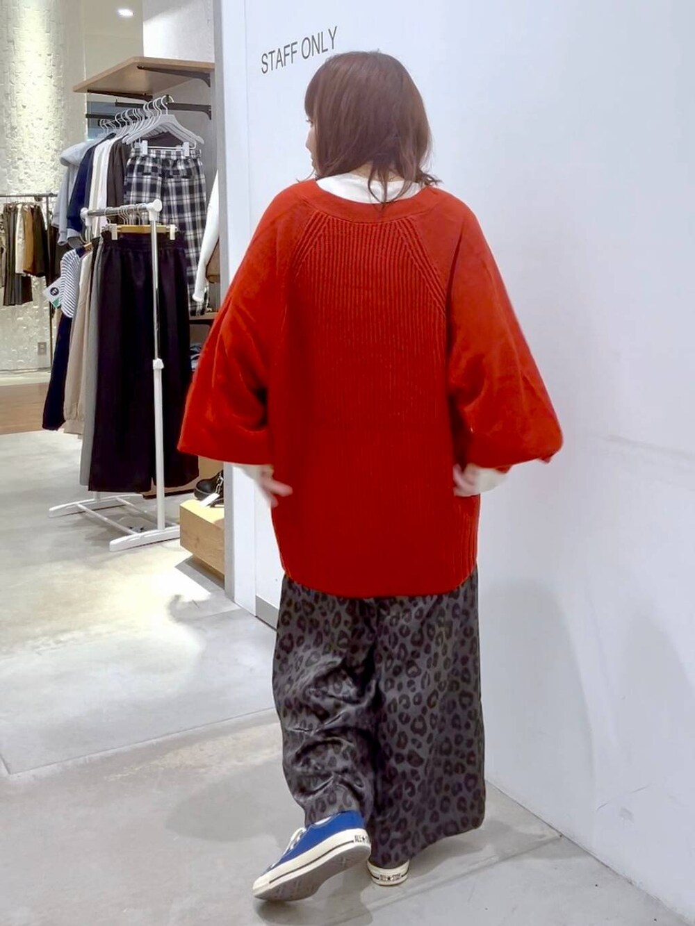 ホワイト系のTシャツ/カットソー、レッド系のカーディガン/ボレロ、ブルー系のスニーカーを着用したレディースの秋コーディネートの4枚目の写真