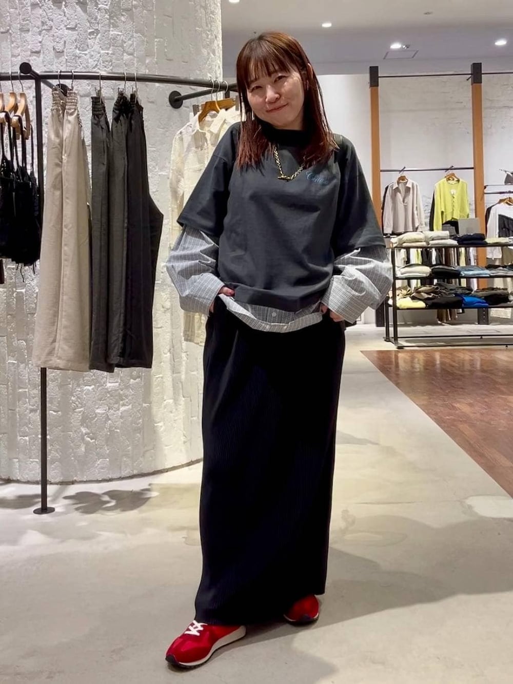 ブラック系のショルダーバッグ、レッド系のスニーカー、グレー系のTシャツ/カットソーを着用したレディースの春コーディネートの2枚目の写真