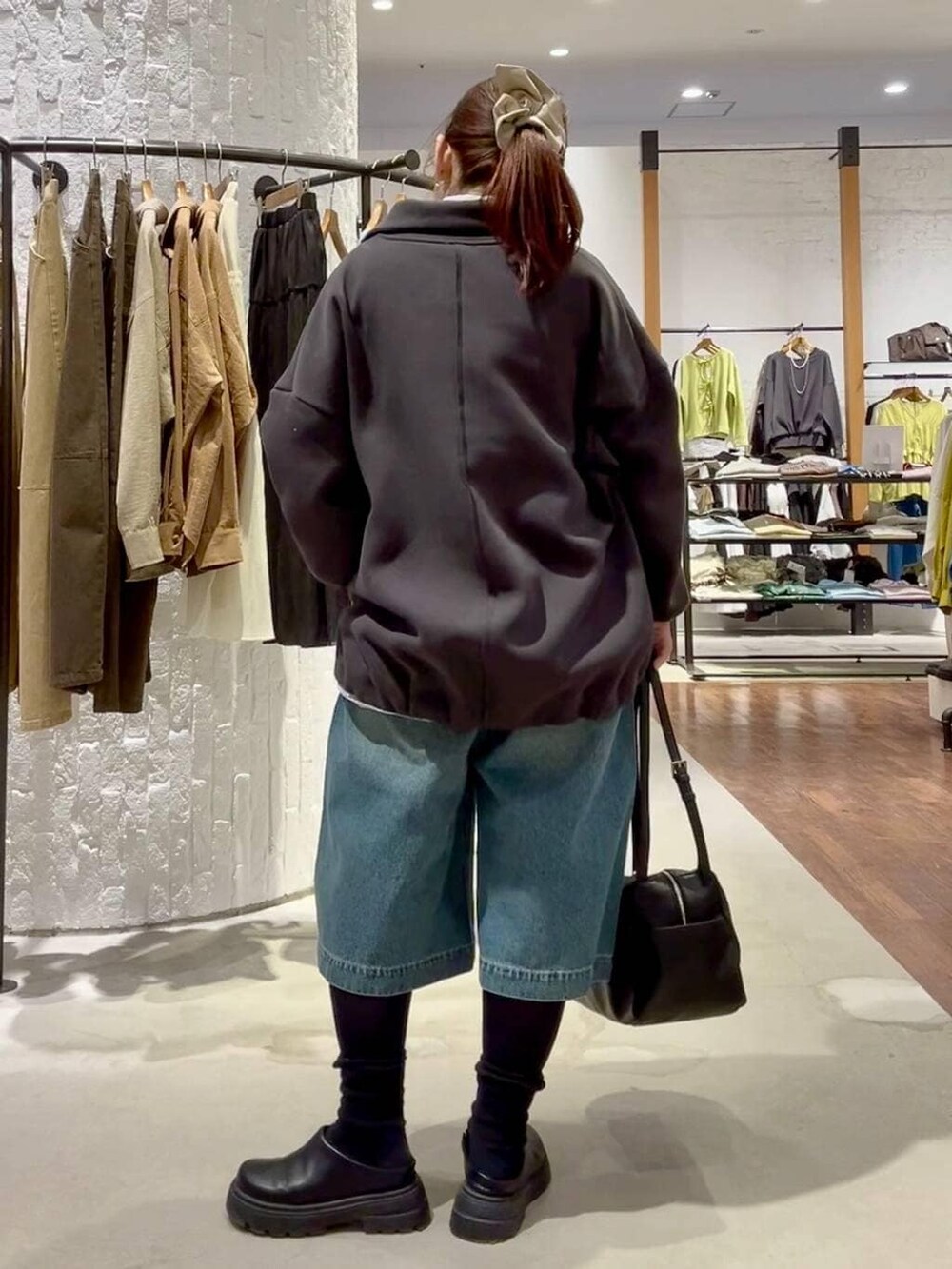 ブラック系のその他シューズ、ブラック系のボストンバッグ、ブルー系のデニムパンツを着用したレディースの冬コーディネートの5枚目の写真