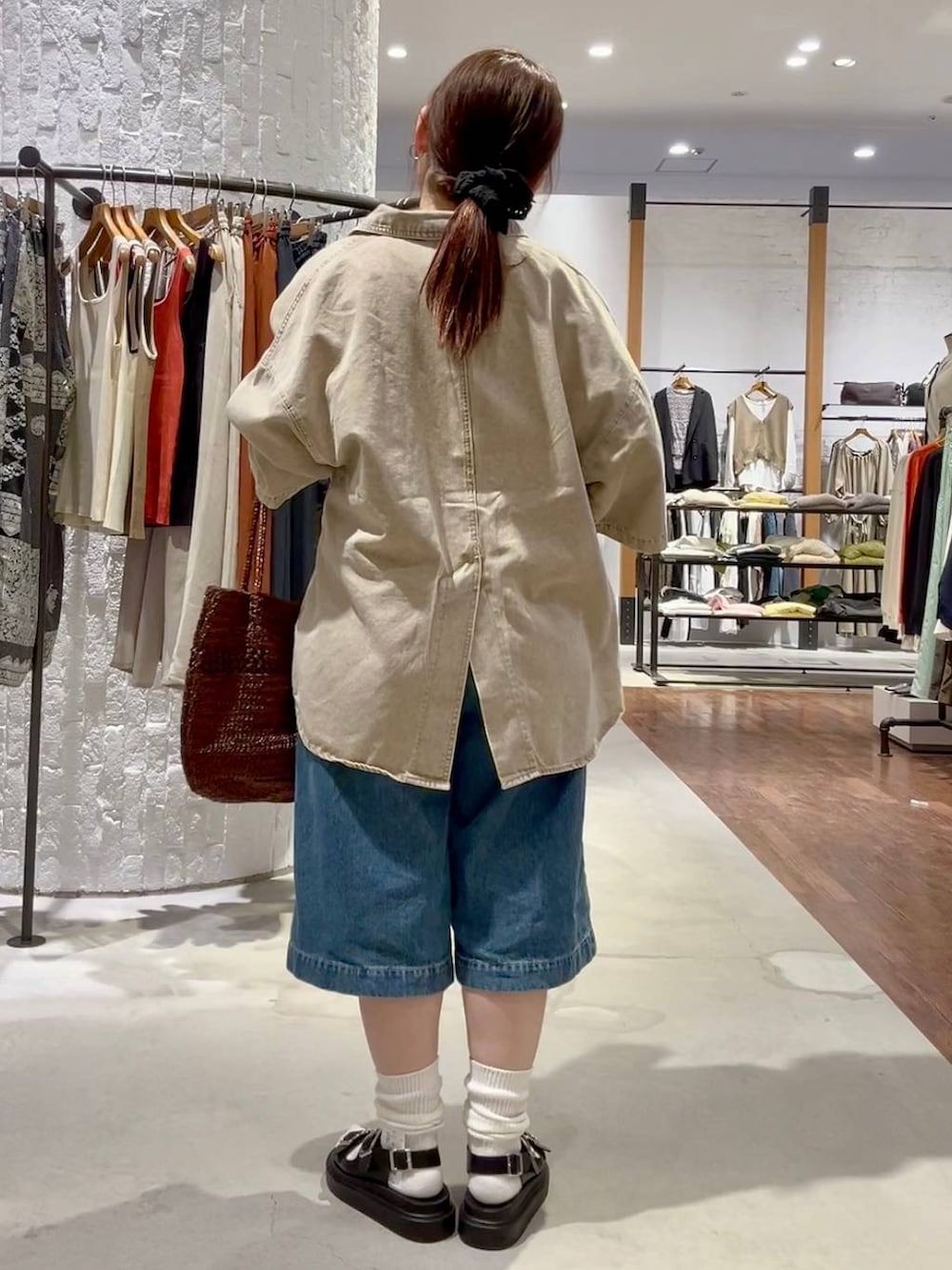 ブラック系のサンダル、ブルー系のデニムパンツ、ホワイト系のTシャツ/カットソーを着用したレディースの春コーディネートの5枚目の写真