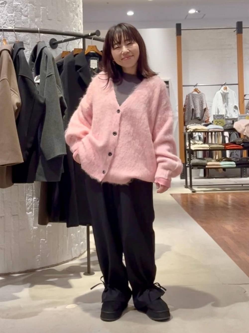 グレー系のニット/セーター、ブラック系のその他パンツ、ピンク系のカーディガン/ボレロを着用したレディースの秋コーディネートの2枚目の写真