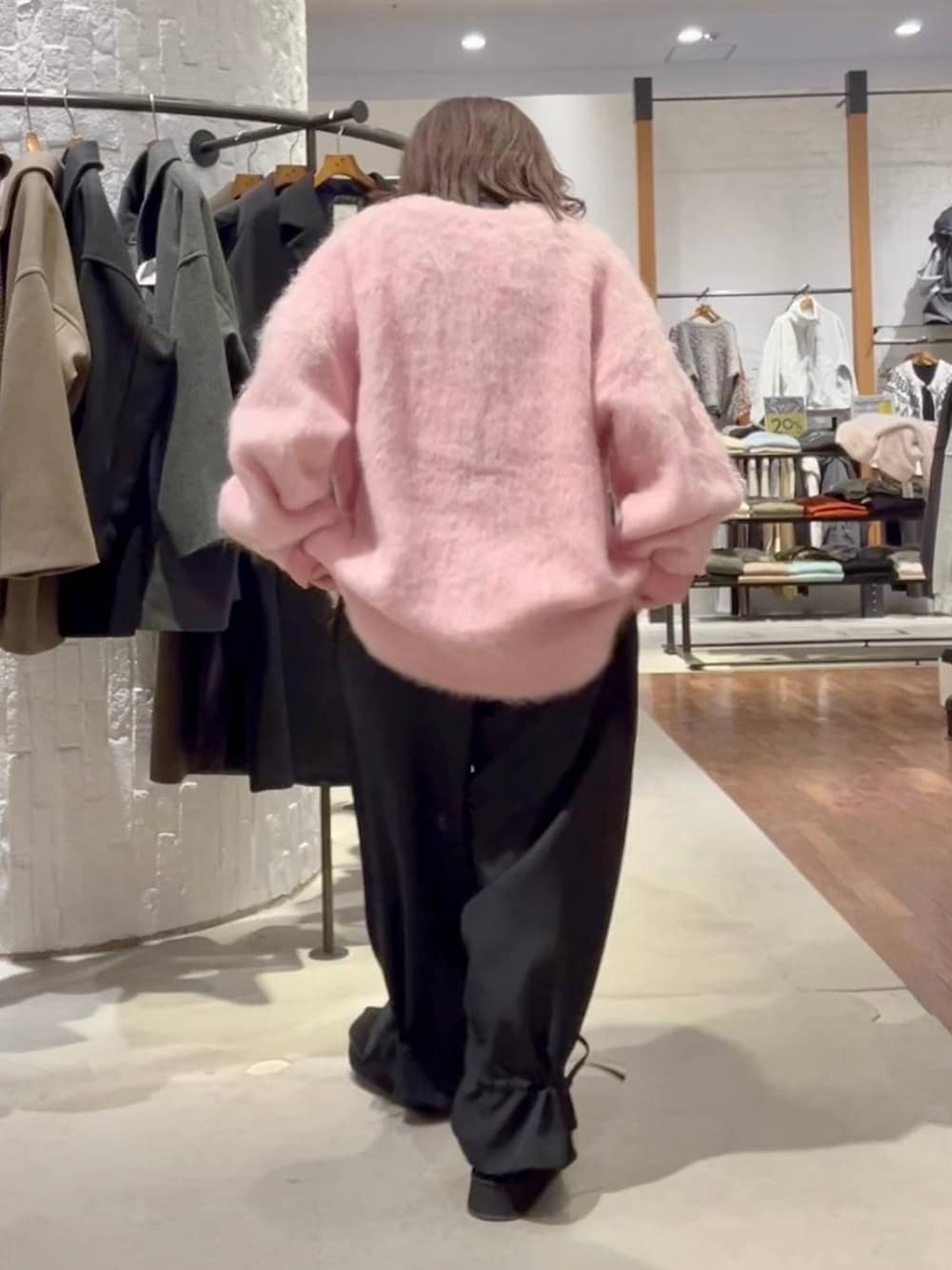 グレー系のニット/セーター、ブラック系のその他パンツ、ピンク系のカーディガン/ボレロを着用したレディースの秋コーディネートの5枚目の写真