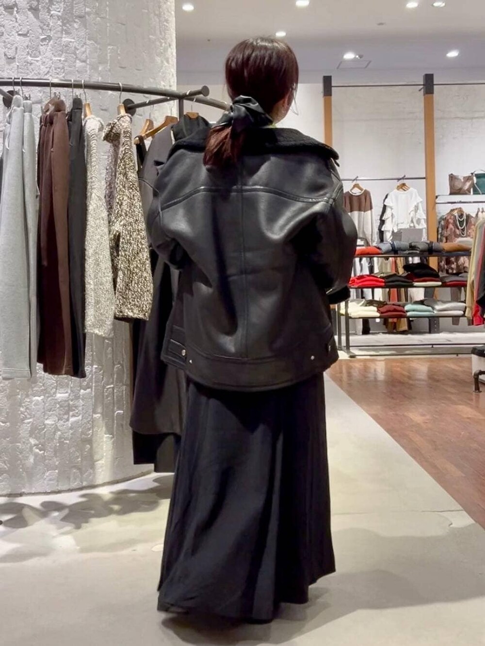 ブラック系のショルダーバッグ、ブラック系のその他アウター、ブラック系のブーツを着用したレディースの冬コーディネートの5枚目の写真