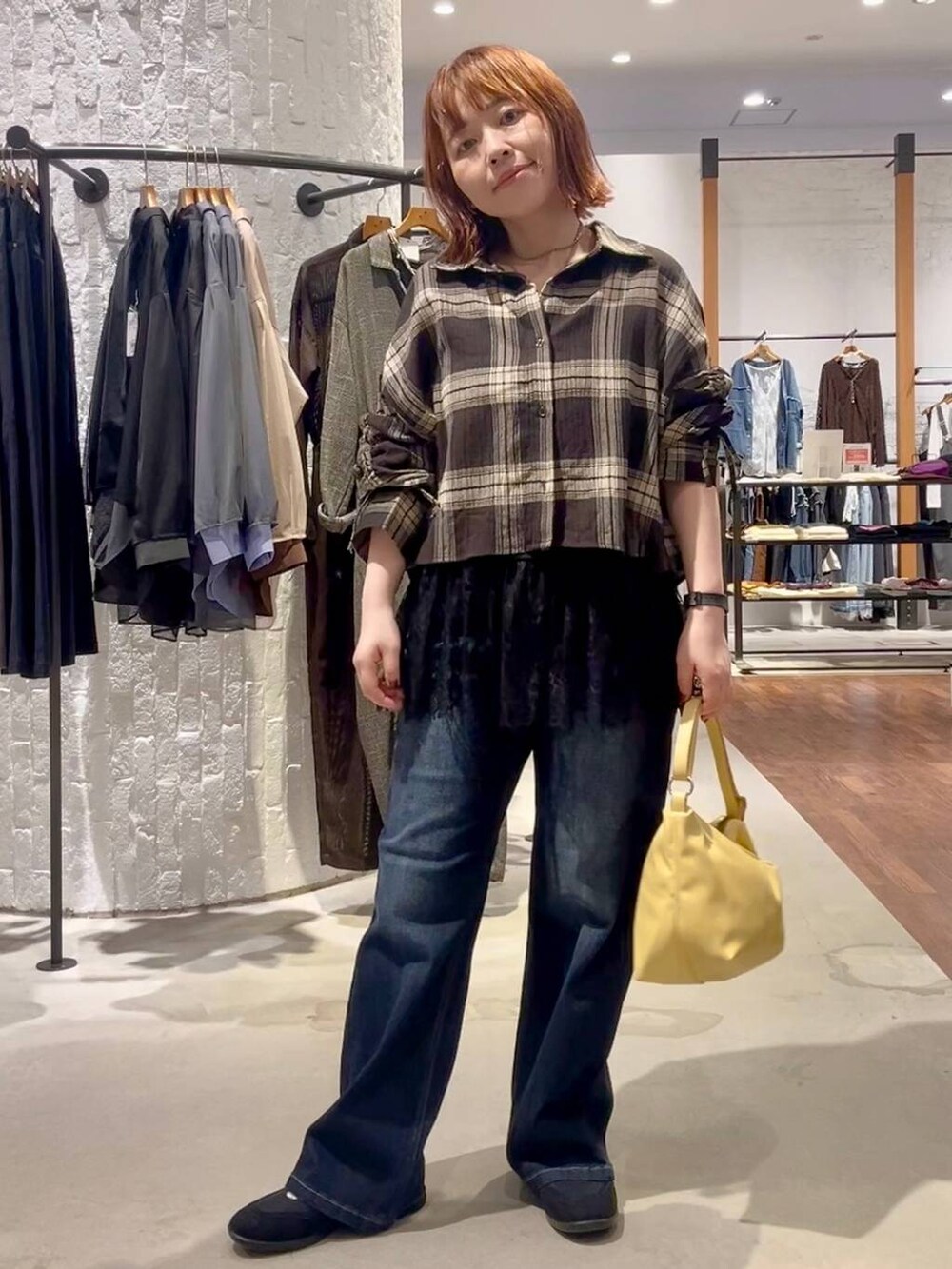 ブラック系のパンプス、ブラウン系のシャツ/ブラウス、イエロー系のショルダーバッグを着用したレディースの夏コーディネートの2枚目の写真