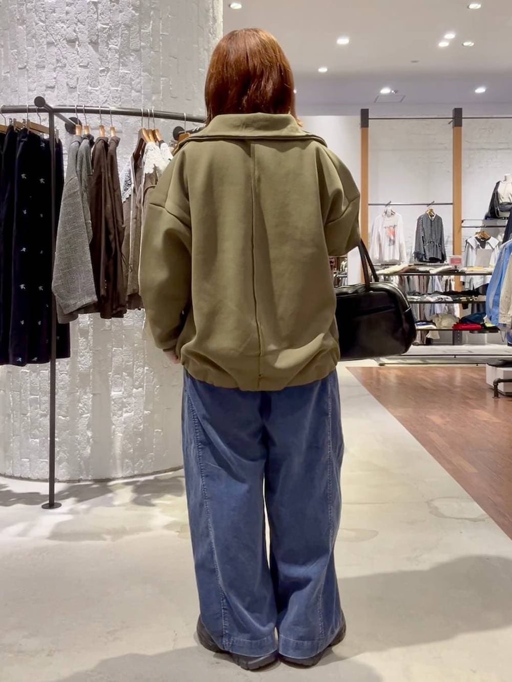 ブラウン系のローファー、ブルー系のその他パンツ、ブラック系のボストンバッグを着用したレディースの秋コーディネートの4枚目の写真
