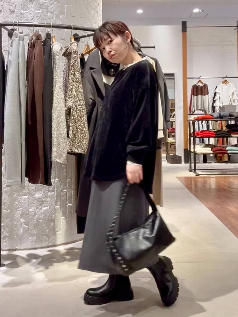 ブラック系のブーツ、ブラック系のデニムジャケット、ブラック系のハンドバッグを着用したレディースの秋コーディネートの8枚目の写真