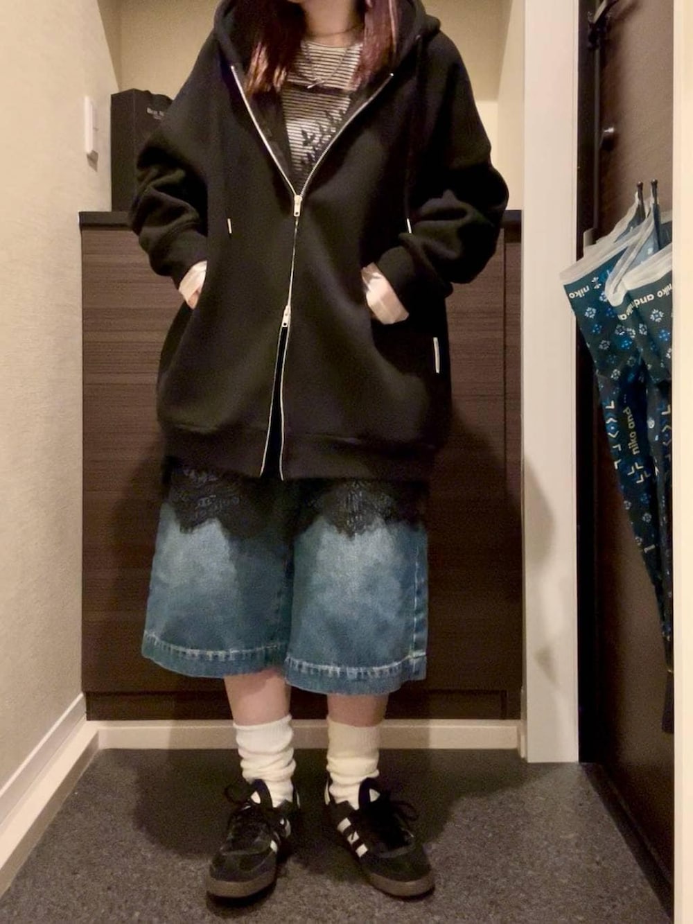 ブラック系のブルゾン、ホワイト系のTシャツ/カットソー、ブラック系のスニーカーを着用したレディースの春コーディネートの2枚目の写真