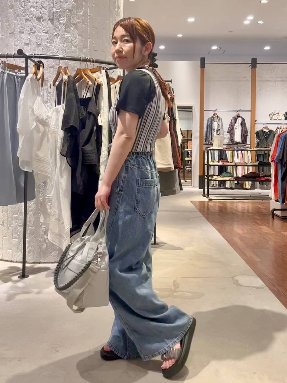 ブラック系のTシャツ/カットソー、ブルー系のデニムパンツ、グレー系のショルダーバッグを着用したレディースの夏コーディネートの3枚目の写真