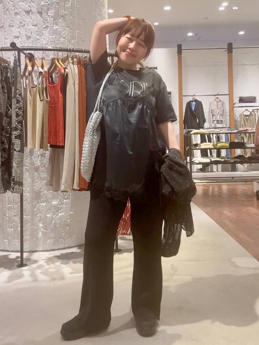 ブラック系のその他パンツ、ブラック系のその他シューズ、シルバー系のショルダーバッグを着用したレディースの春コーディネートの6枚目の写真